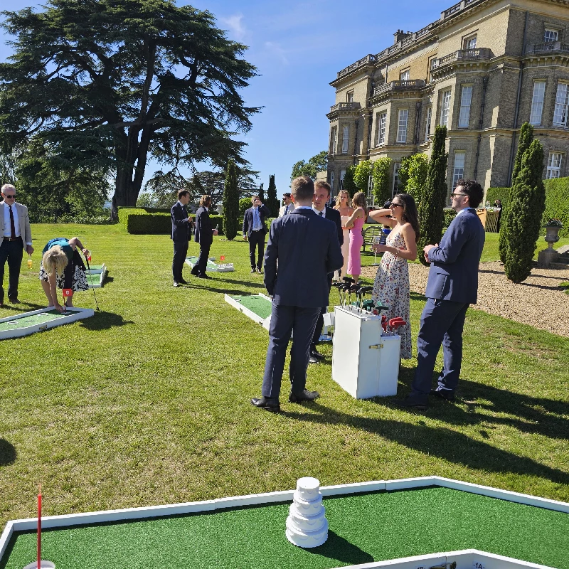 crazy golf hire uk at Hedsor House. Wedding guests playing , laughing and drinking Champagne in the sunshine.